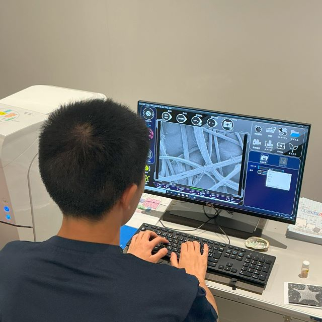走査電子顕微鏡で試料を調べる生徒
