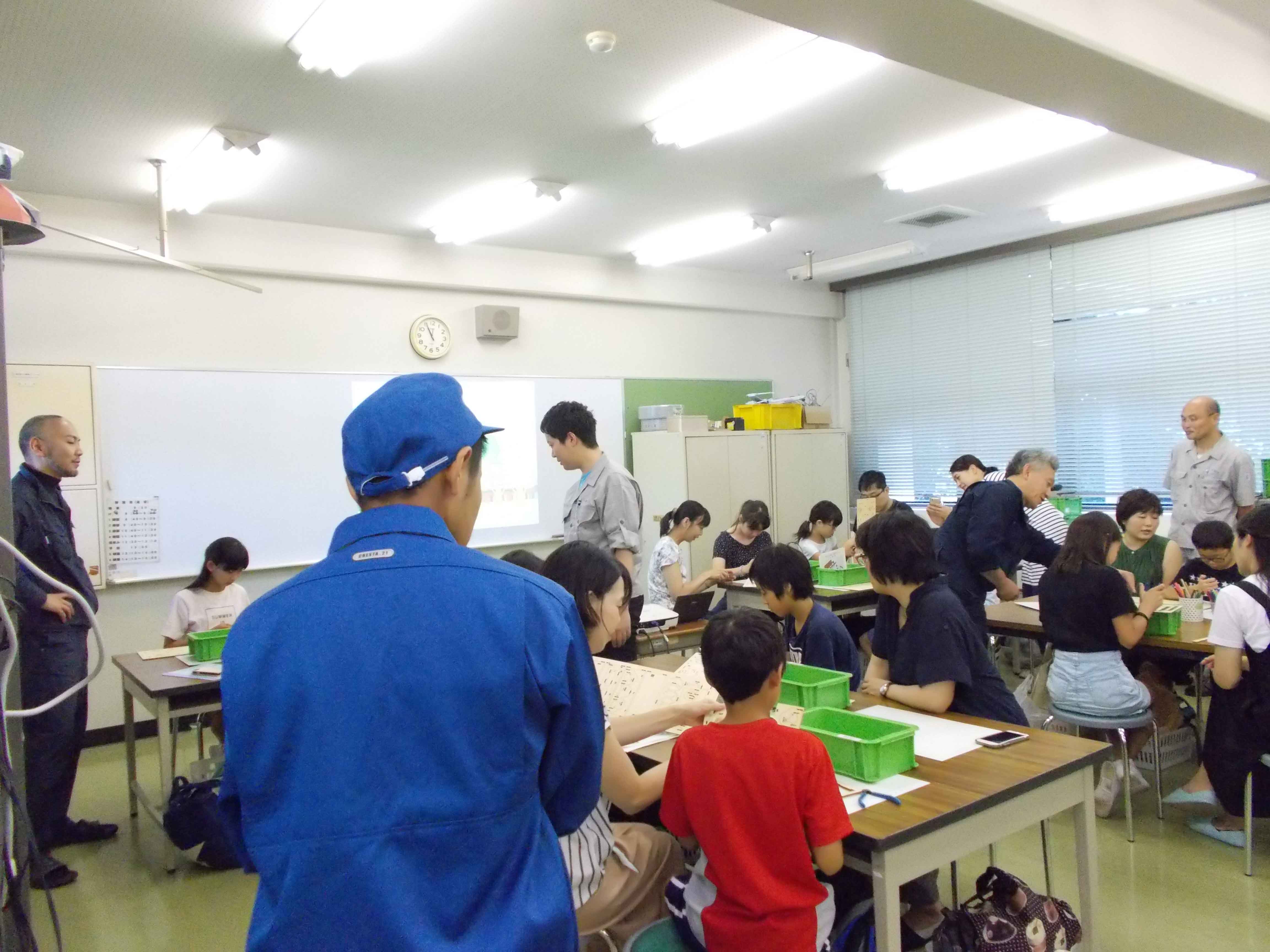 缶バッチを製作する参加者の小学生