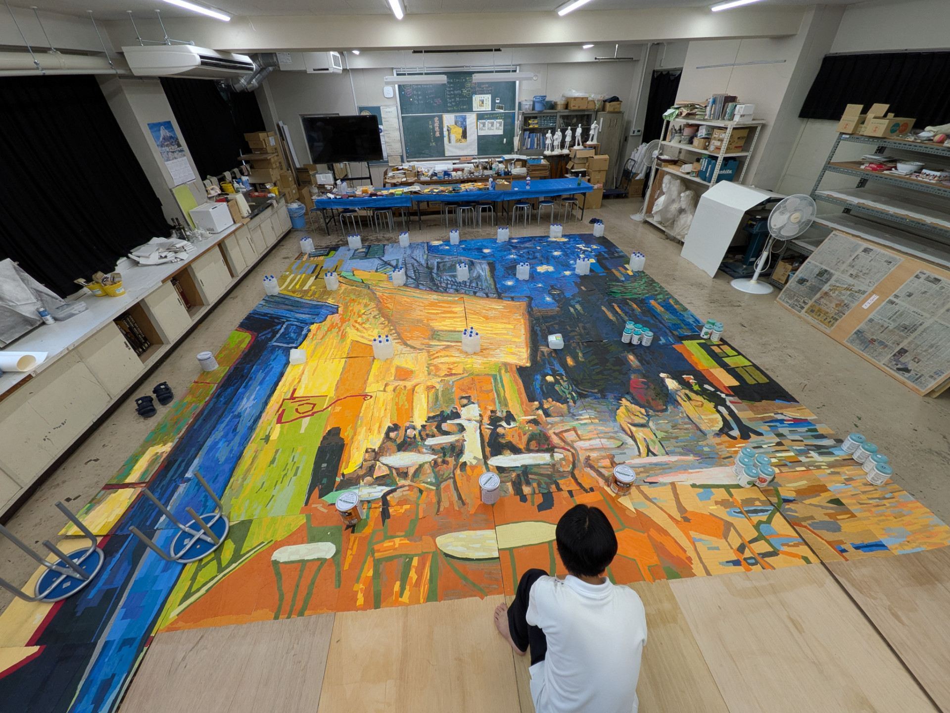 美術室の床に広げられた巨大貼り絵の全景と制作の様子