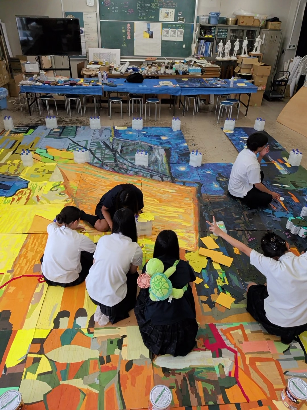 美術室で巨大貼り絵を囲んで制作する様子